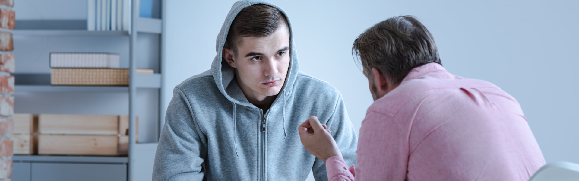 man in a hoodie listening to the therapist